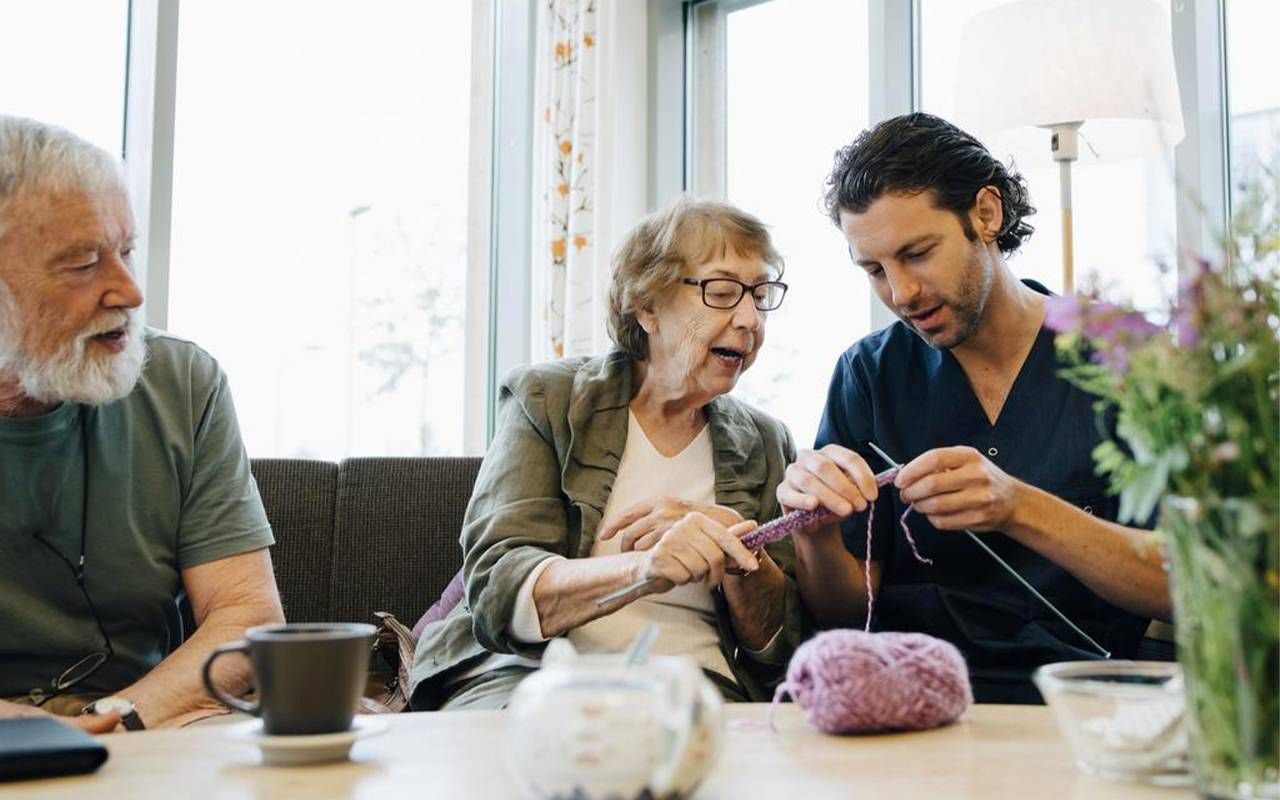 A male caregiver learning how to knit with his loved one. Next Avenue