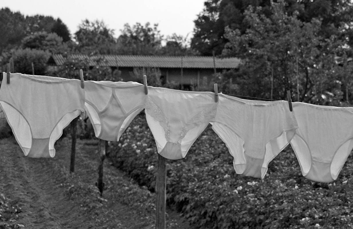 A black and white photo of underwear hanging on a clothes line. Next Avenue, menstruation, incontinence