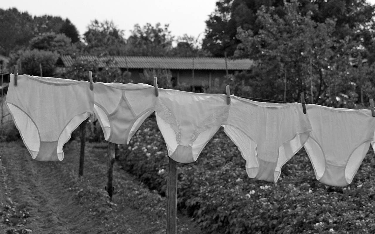 A black and white photo of underwear hanging on a clothes line. Next Avenue, menstruation, incontinence