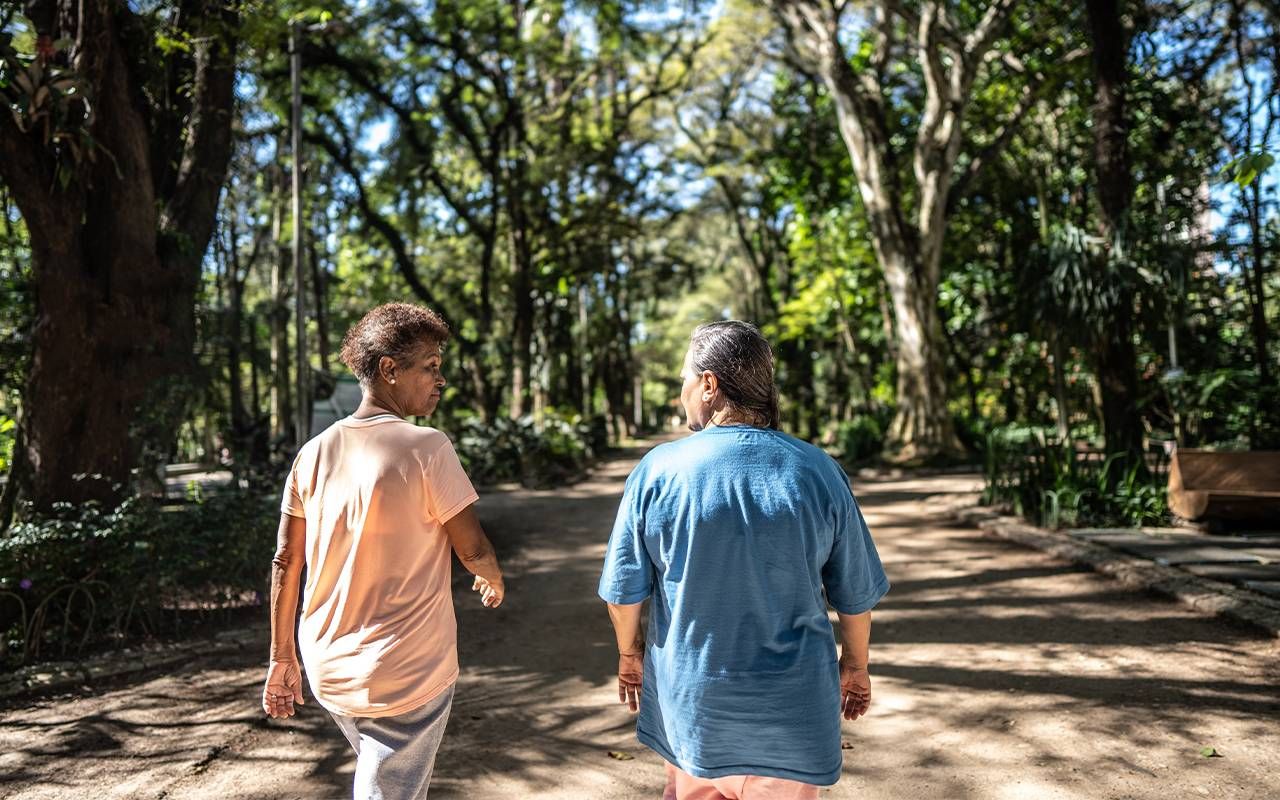 Two friends walking together. Next Avenue, caregiving, alzheimer's