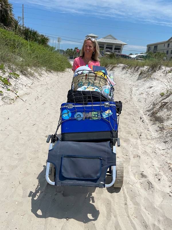 A person pushing a cart on the beach. Next Avenue