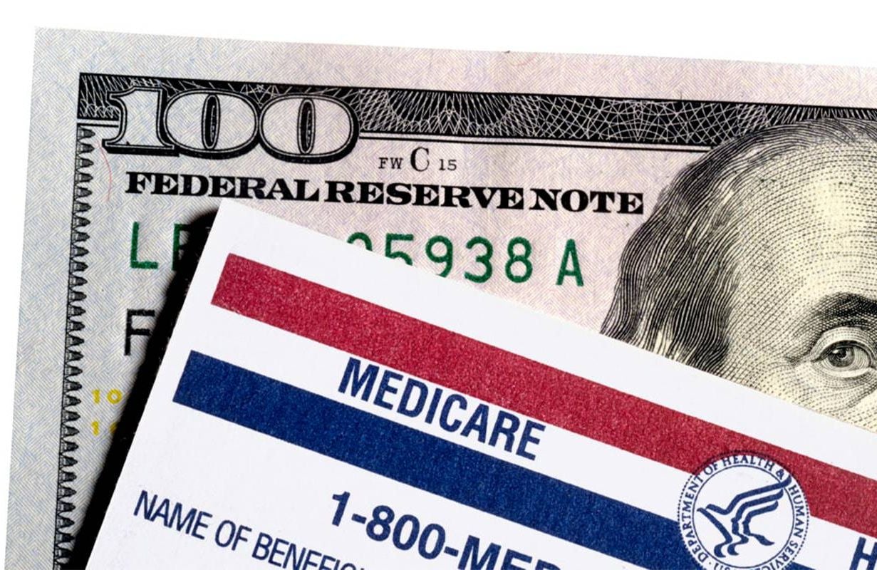 A $100 bill behind a Medicare Health card. Next Avenue