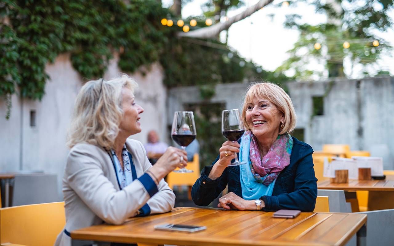 Two women toasting while out to dinner. Next Avenue