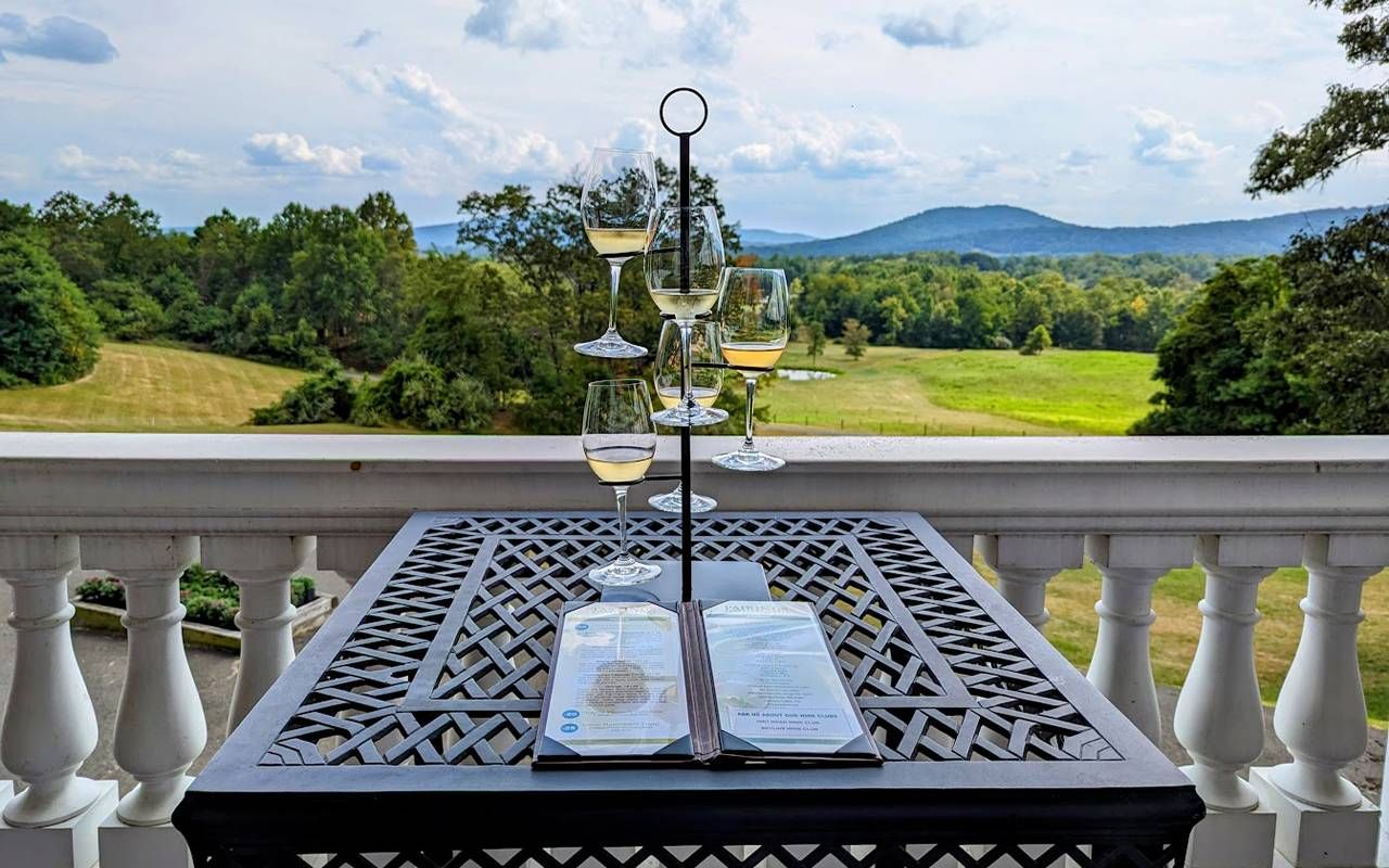 A table with wine glasses overlooking a mountain range. Next Avenue