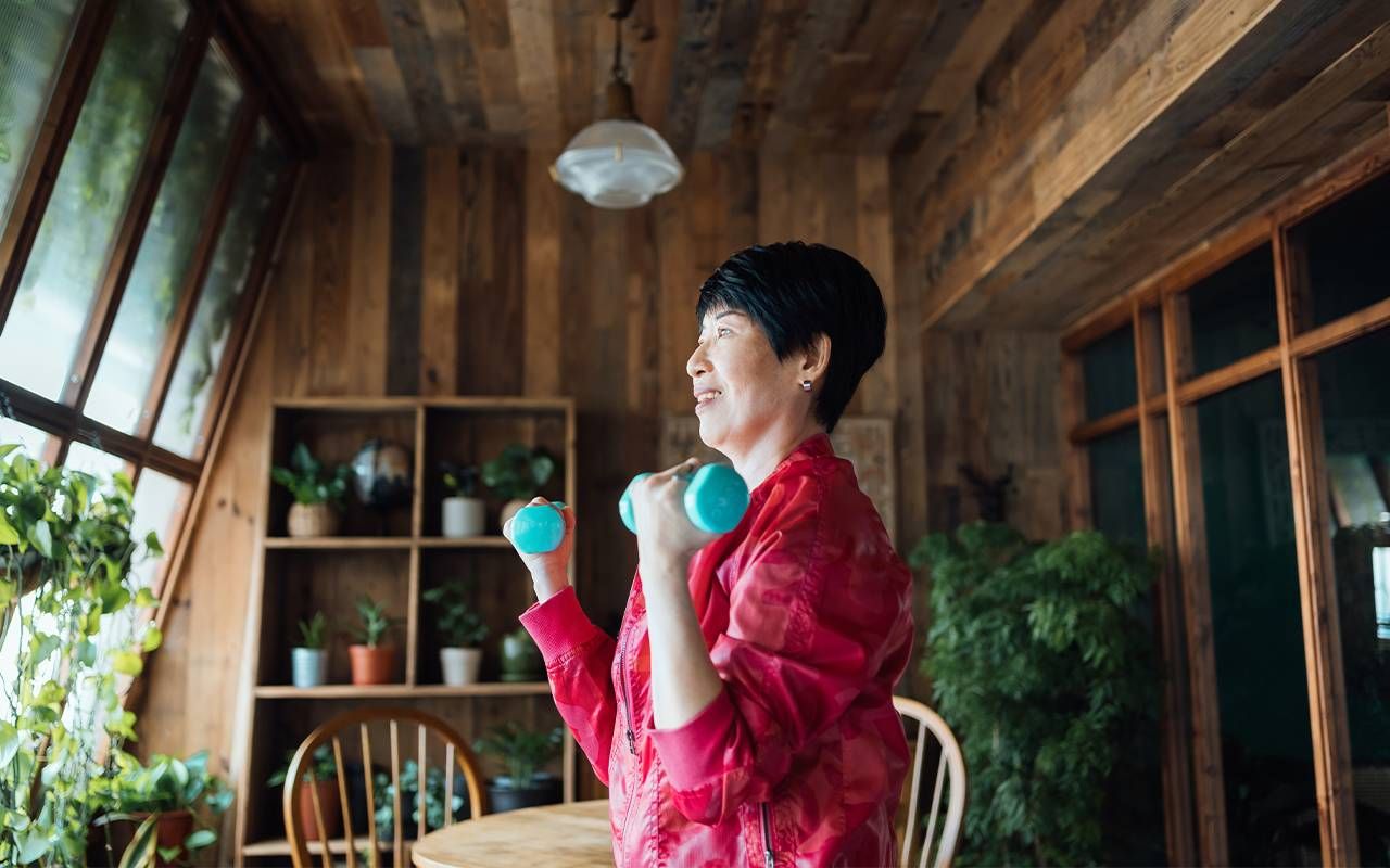 A woman using free weights at home. Next Avenue, strength training