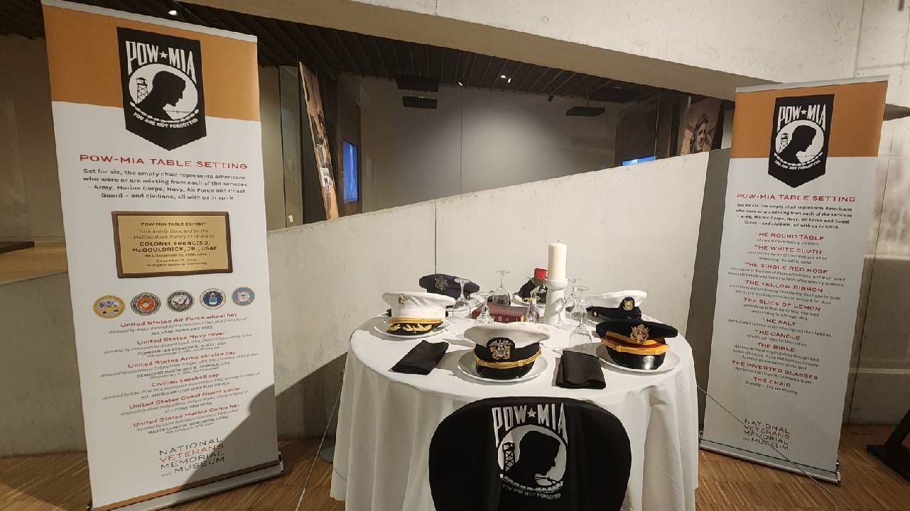 A table set with hats from the various branches of the military. Next Avenue, national veterans memorial and museum