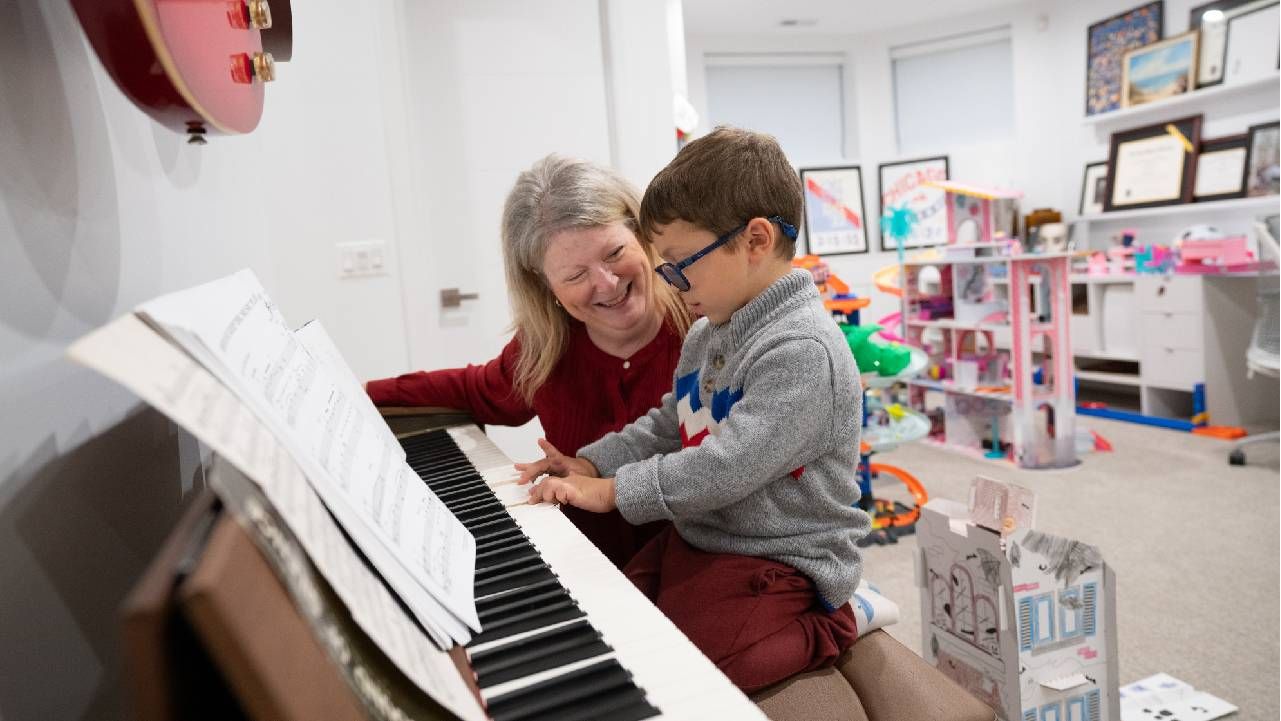 A woman and her grandson playing piano. Next Avenue, parents move in