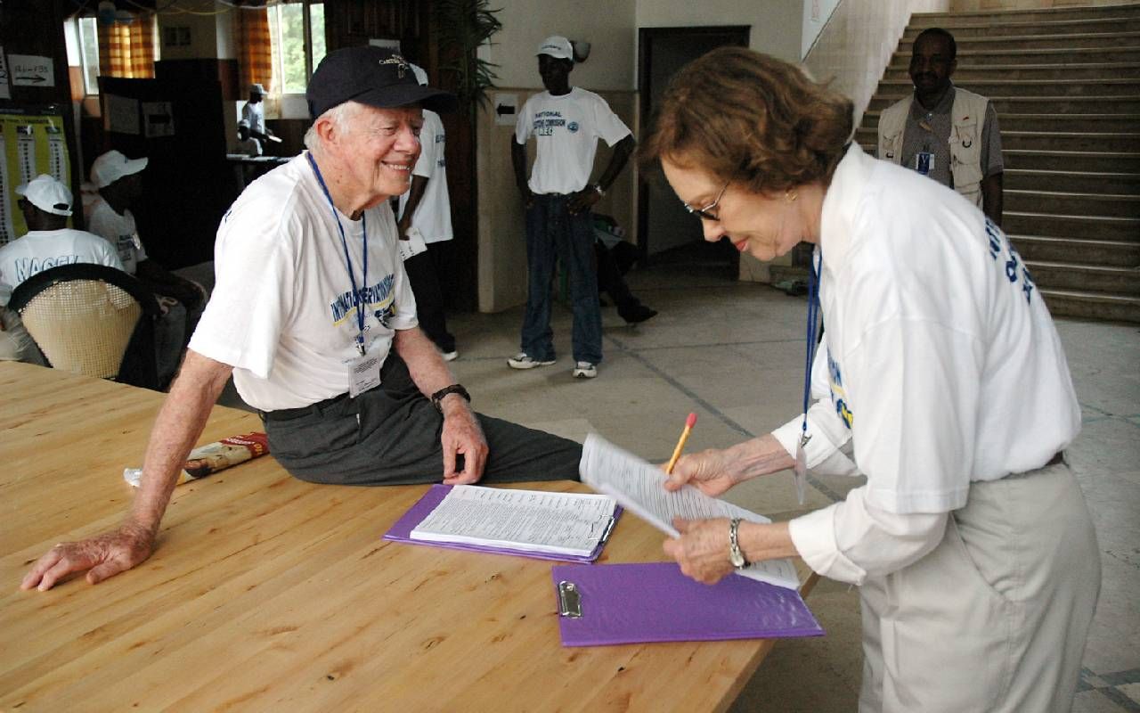 President Jimmy Carter and First Lady Rosalynn Carter smiling and sorting through paperwork. Next Avenue