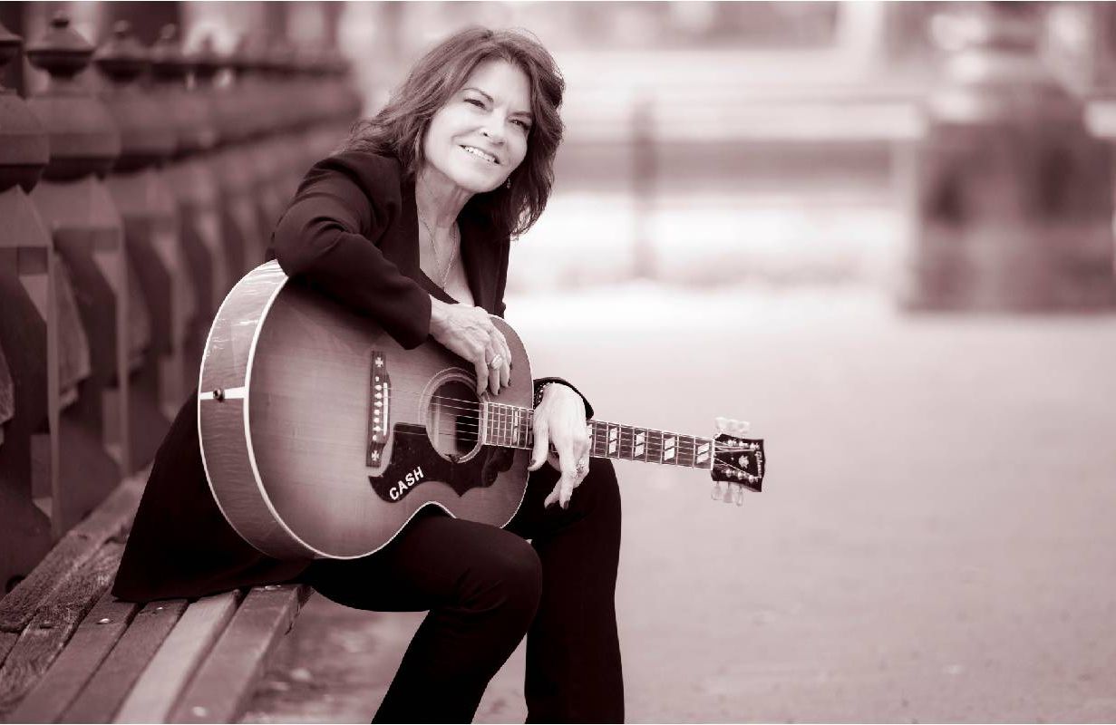 A photo of Rosanne Cash holding a guitar. Next Avenue