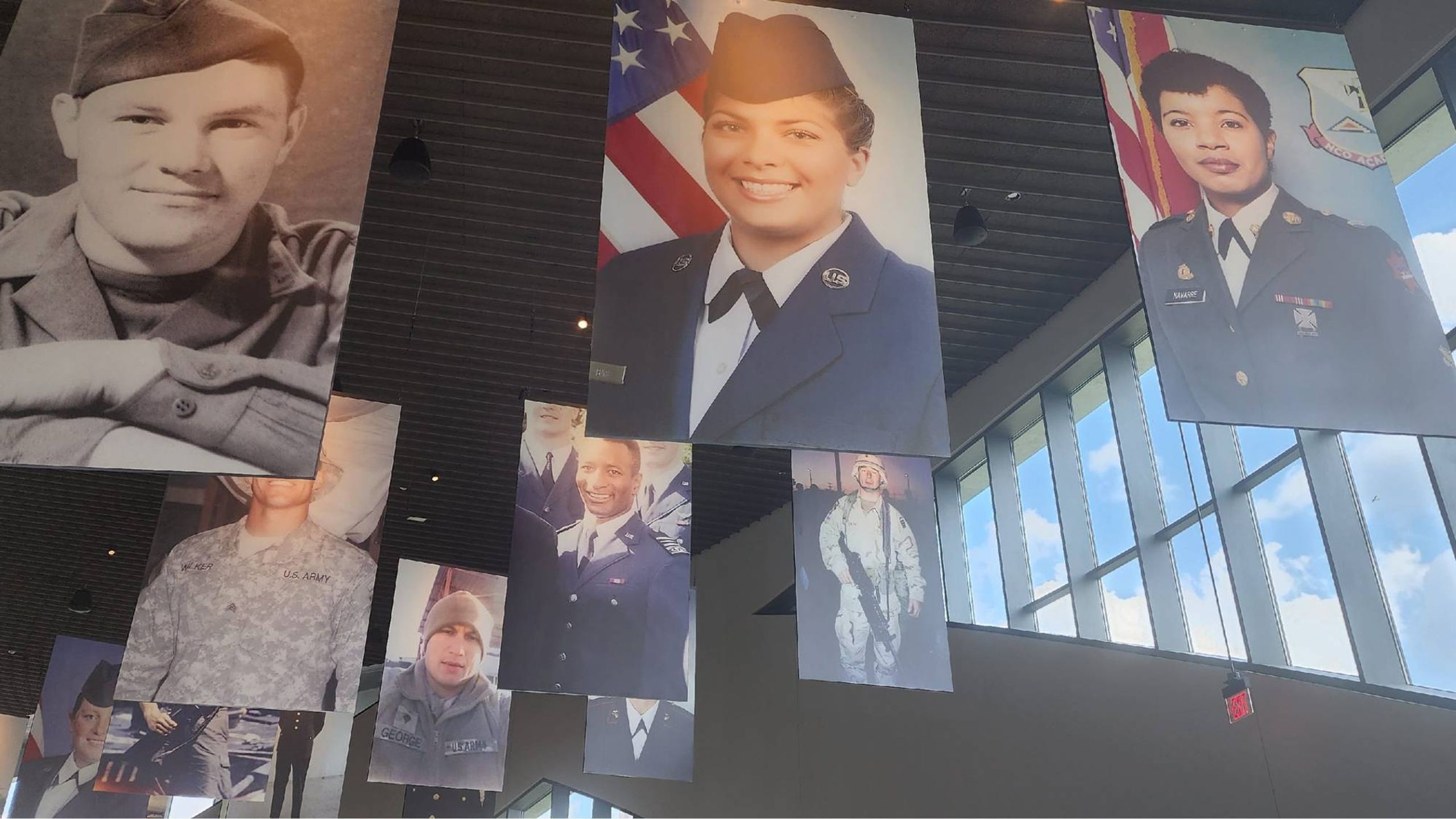 Large portraits of veterans hanging from the ceiling. Next Avenue, national veterans memorial and museum