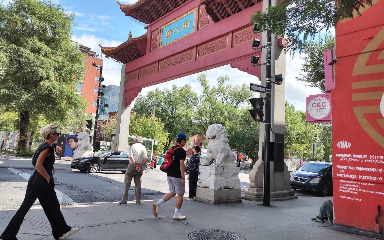 Pedestrians walking underneath an archway in Montreal's Chinatown neighborhood. Next Avenue