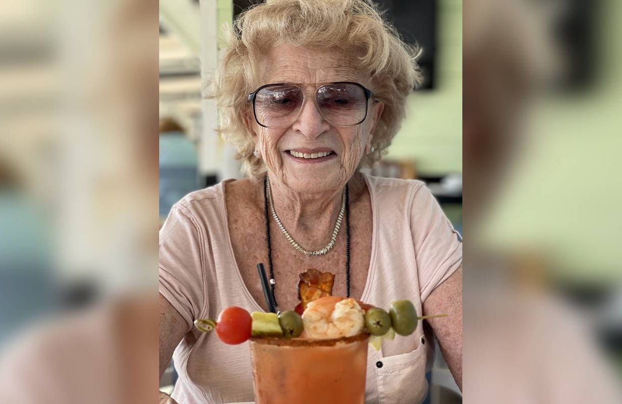 Headshot of Mildred Kirschenbaum with a bloody mary in front of her. Next Avenue