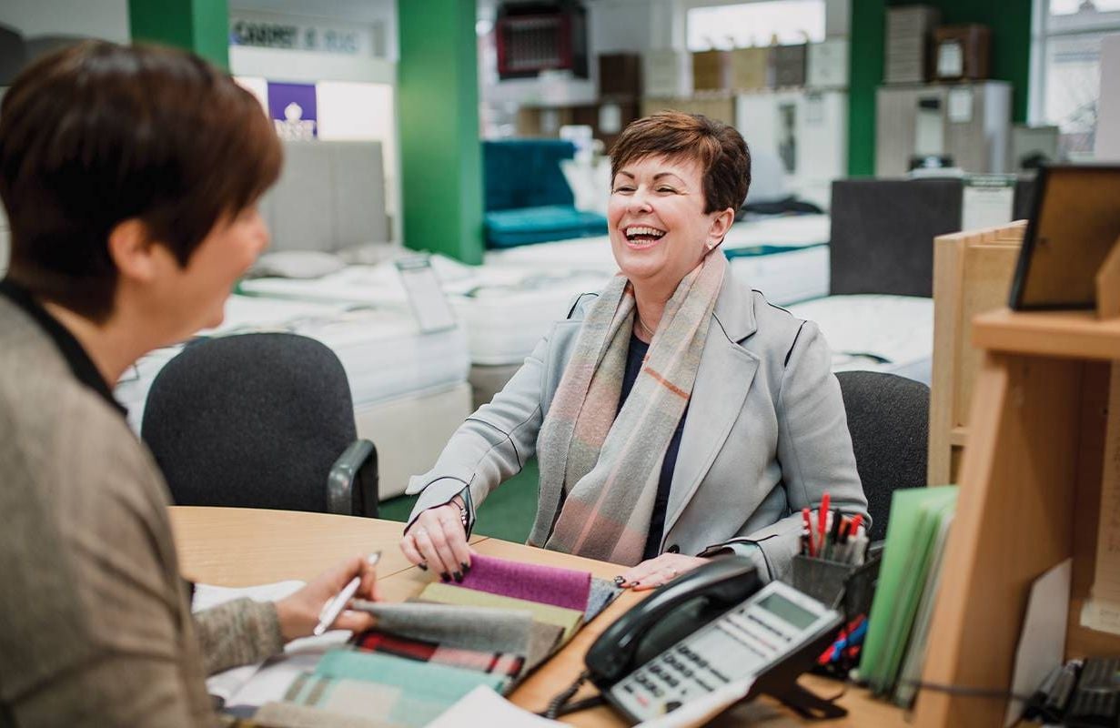 A person laughing with a customer while at work. Next Avenue, change management plan