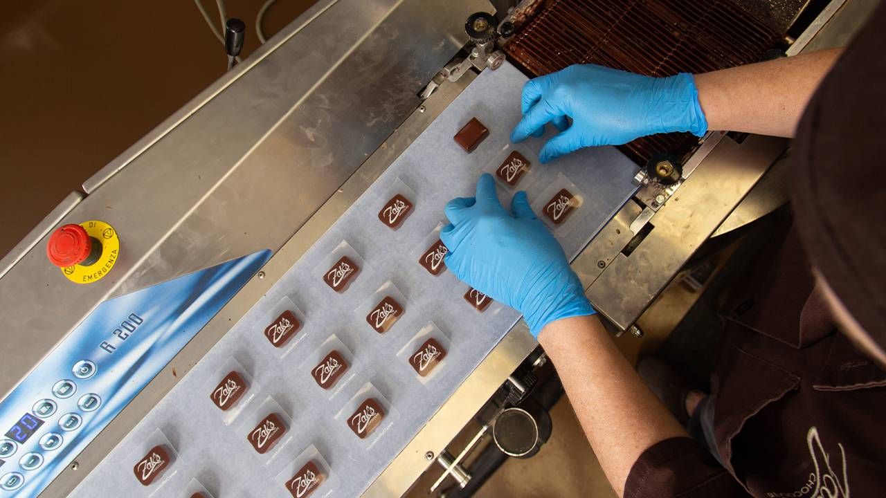 A person working on packaging truffle chocolates. Next Avenue