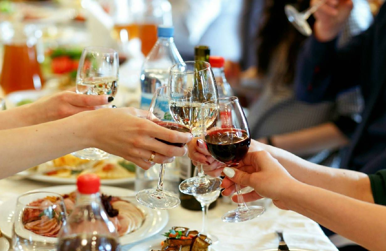 A group of people saying cheers at a cocktail party. Next Avenue, holiday party,