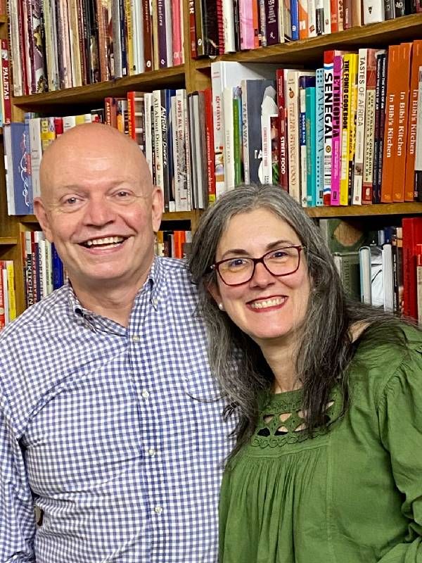 A couple siming together in front of a bookshelf. Next Avenue, cookbook clubs
