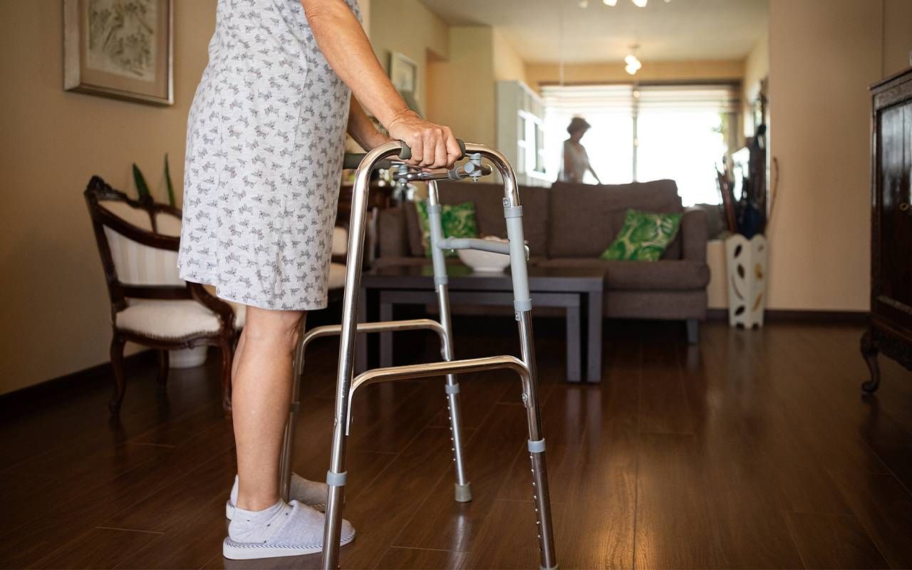 A woman using a walker after getting hip replacement surgery. Next Avenue