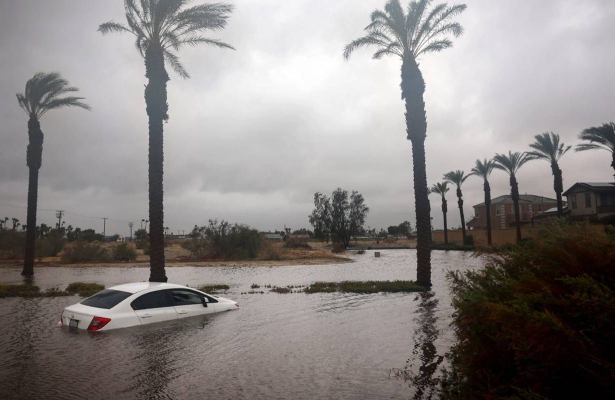 A white car partially submerged in floodwater. Next Avenue, hurricane preparedness
