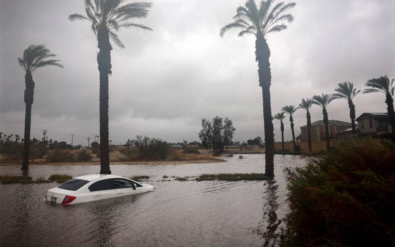 A white car partially submerged in floodwater. Next Avenue, hurricane preparedness