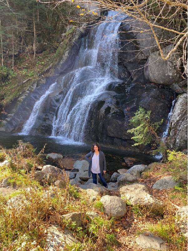 A person standing in front of a waterfall. Next Avenue, hobbies, hiking