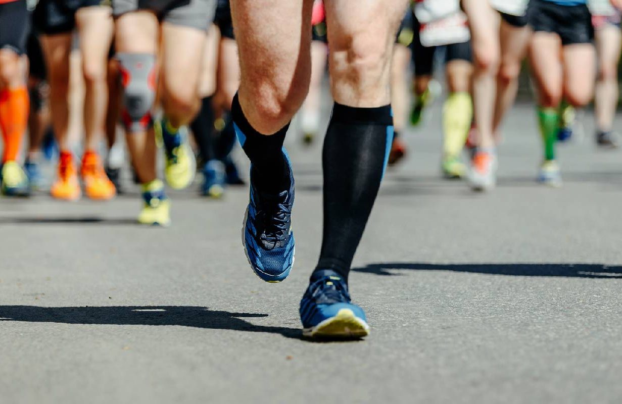 A person wearing compression socks during a race. Next Avenue