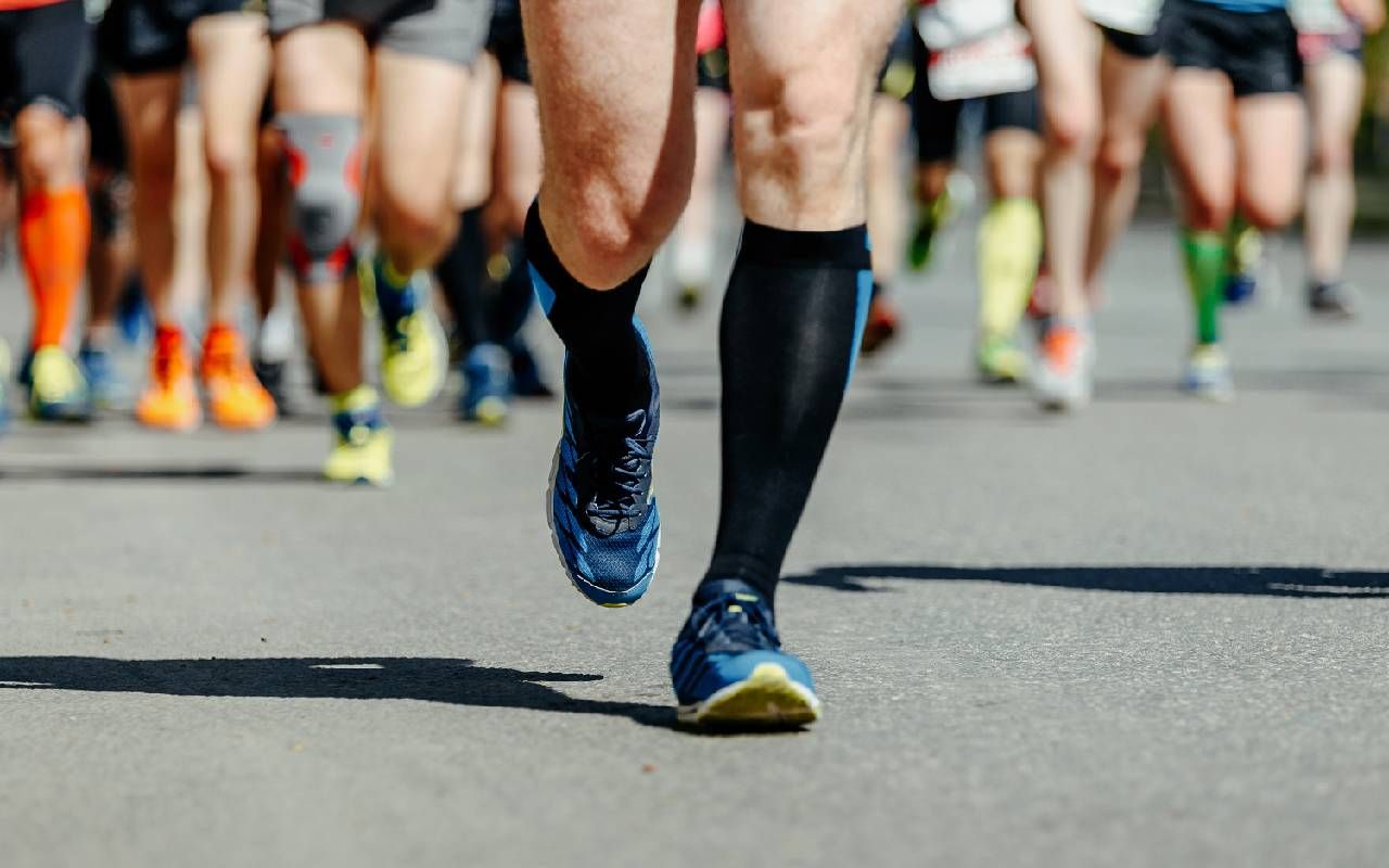 A person wearing compression socks during a race. Next Avenue