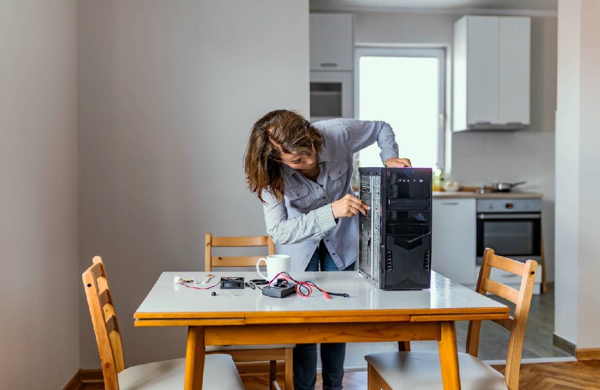 An older adult fixing her computer herself at home. Next Avenue