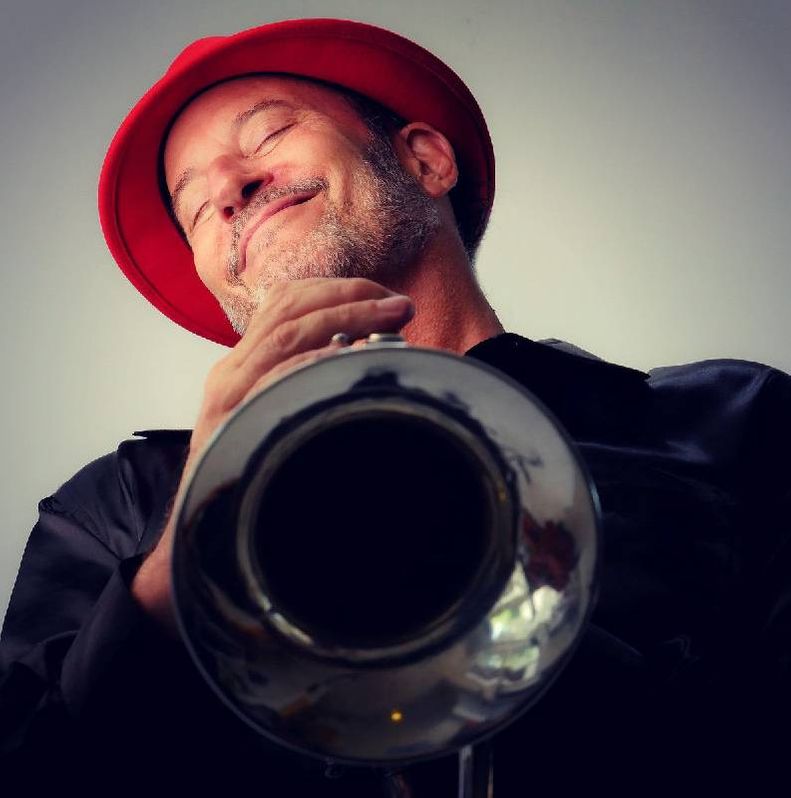 Headshot of a man holding a horned instrument. Next Avenue, caregiving burnout