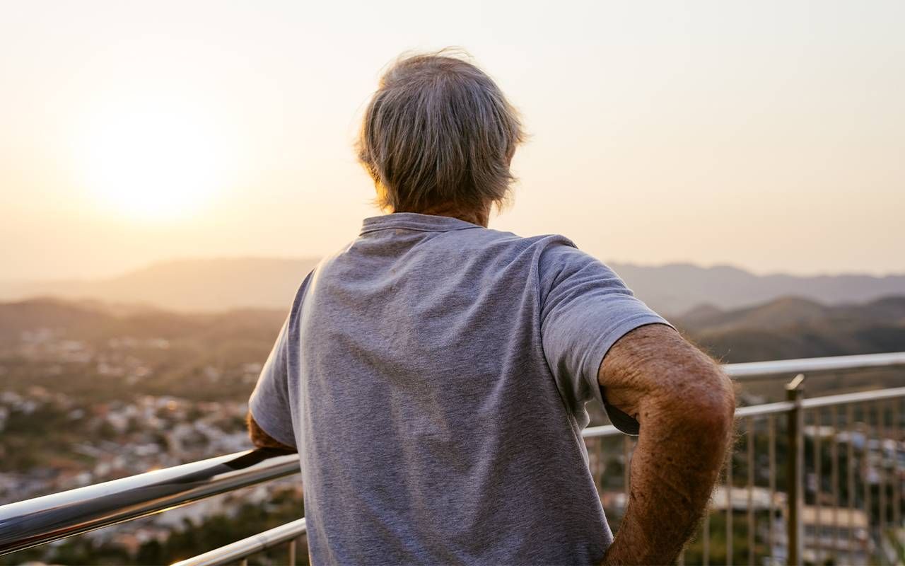 A man looking out at the sunrise. Next Avenue, aging, loss, grief