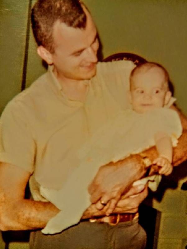 An old photo of a man holding a baby. Next Avenue, assisted living, elder care