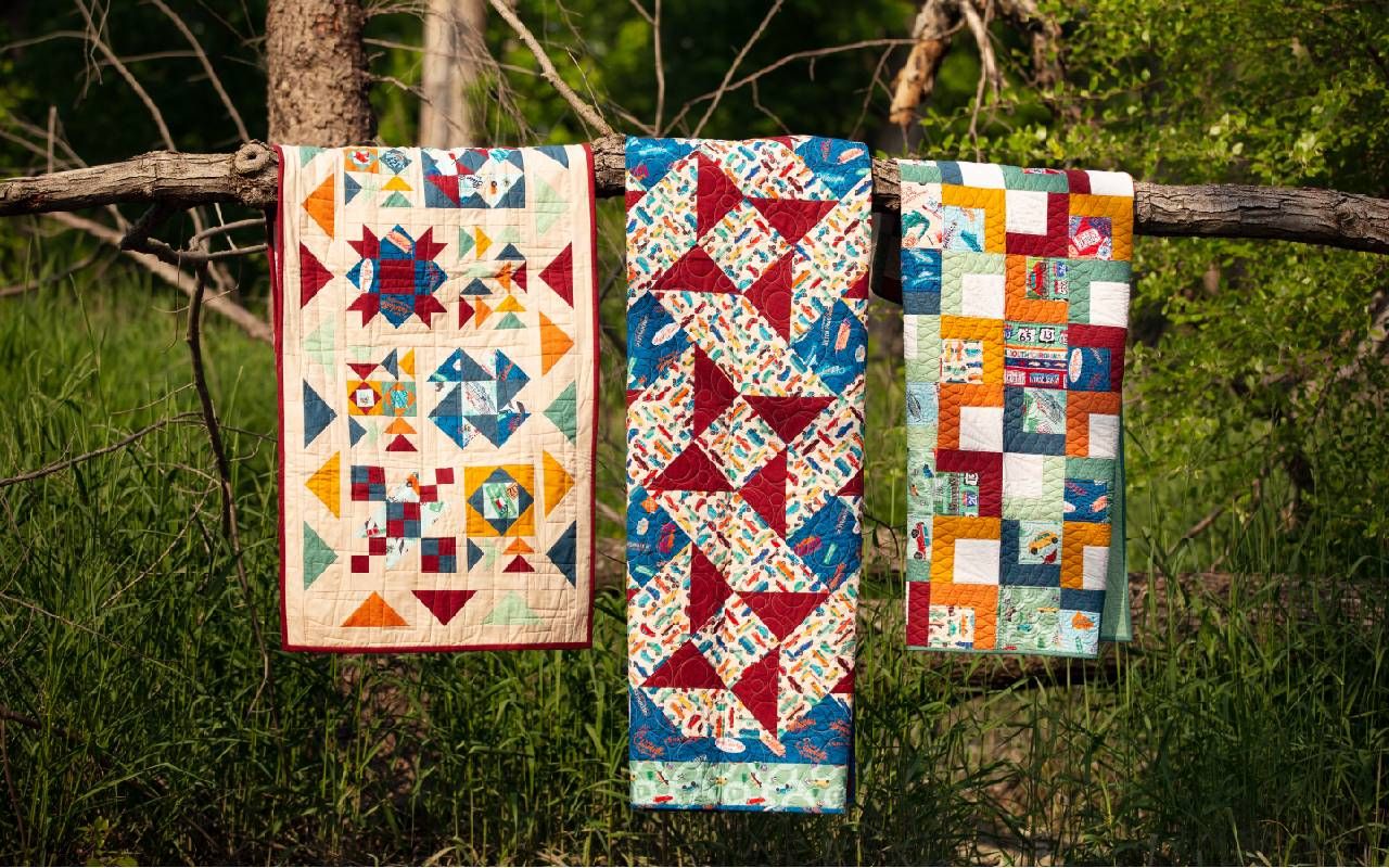 Three quilts on a tree branch. Next Avenue, quilting