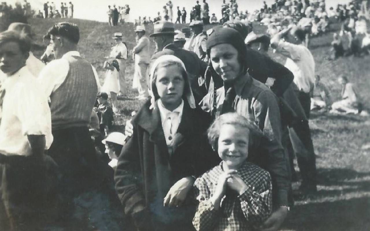 A black and white photo of a woman with two young girls. Next Avenue