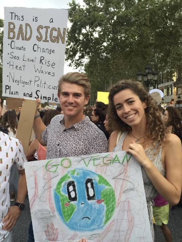 A young man and woman holding signs at a climate change protest. Next Avenue, startups