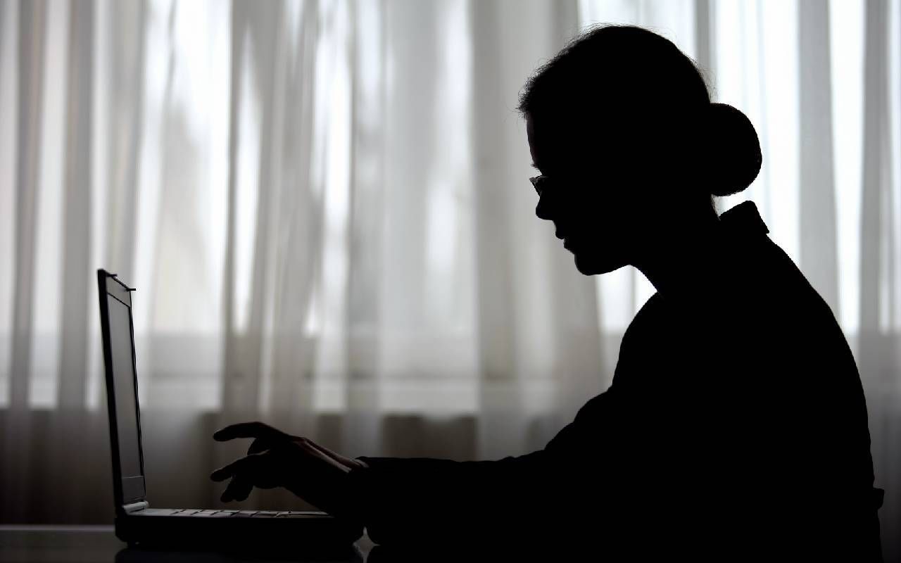 Silhouette of a woman typing on a computer. Next Avenue, regrets