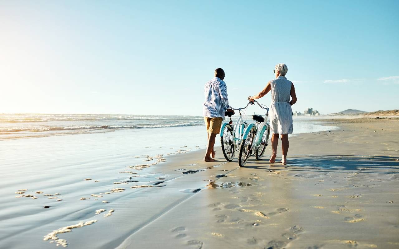 A retired couple walking on the beach. Next Avenue, TIPS, investing