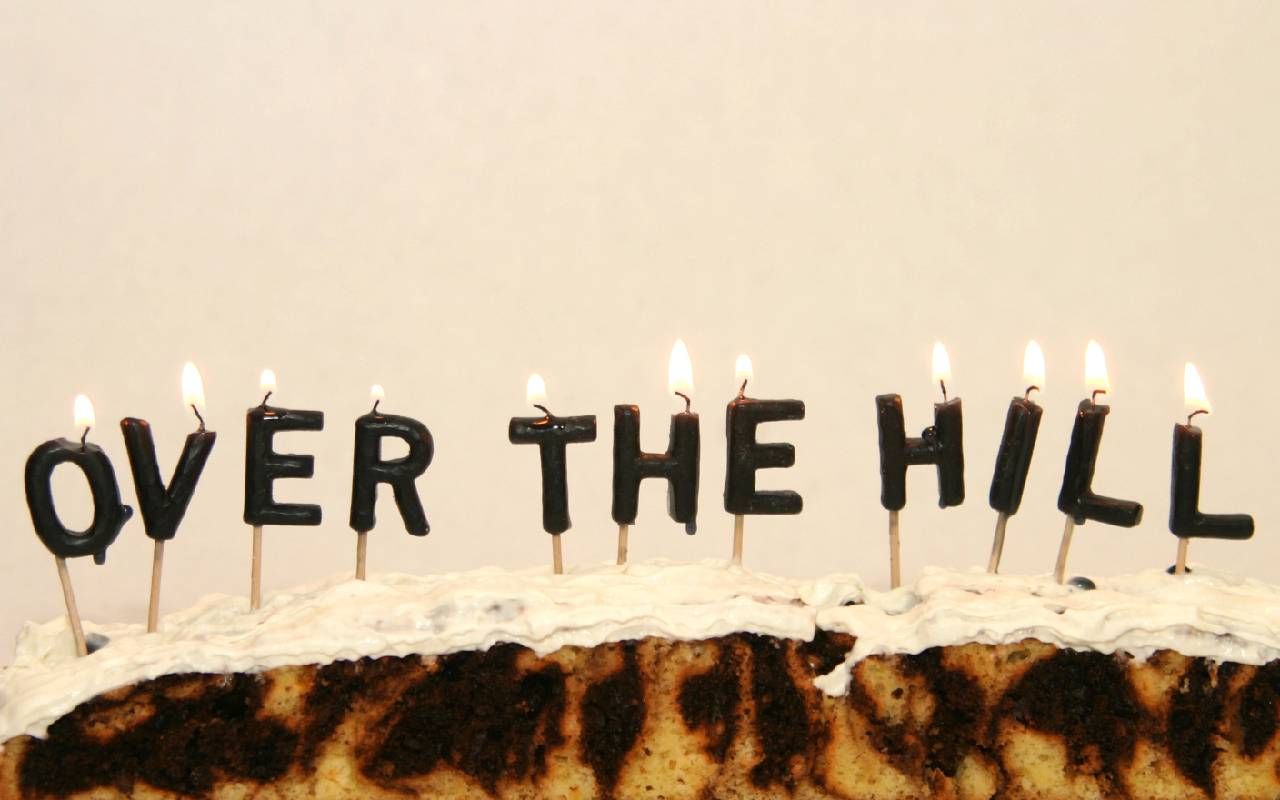 A birthday cake with candles that read "Over the Hill" Next Avenue, ageism, ageist