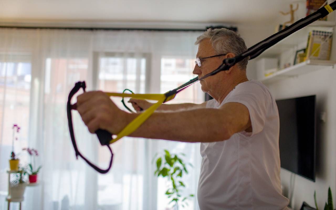 A man doing a strength training exercise at home for chronic pain. Next Avenue