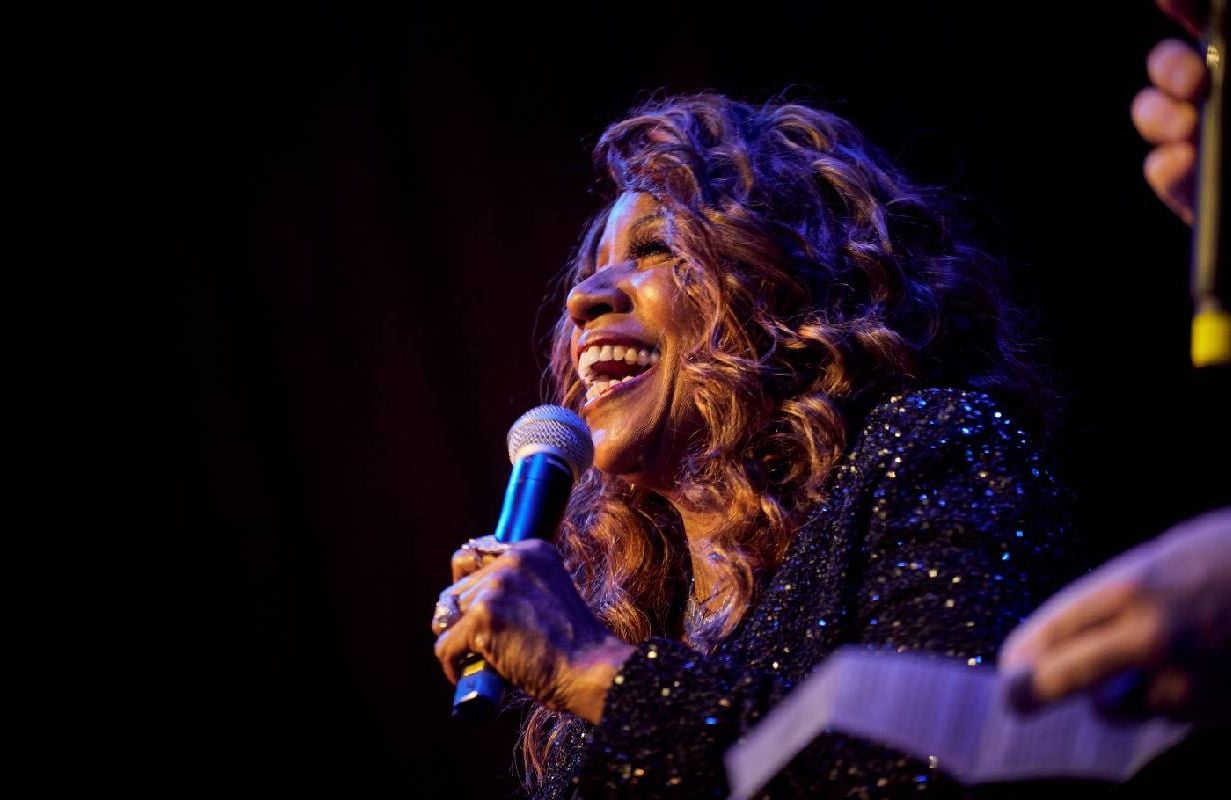 Gloria Gaynor smiling while singing on stage. Next Avenue
