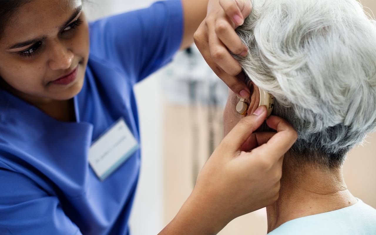 An older adult with hearing loss getting fitted for hearing aids. Next Avenue, hearing loss, cognitive decline, alzheimer's