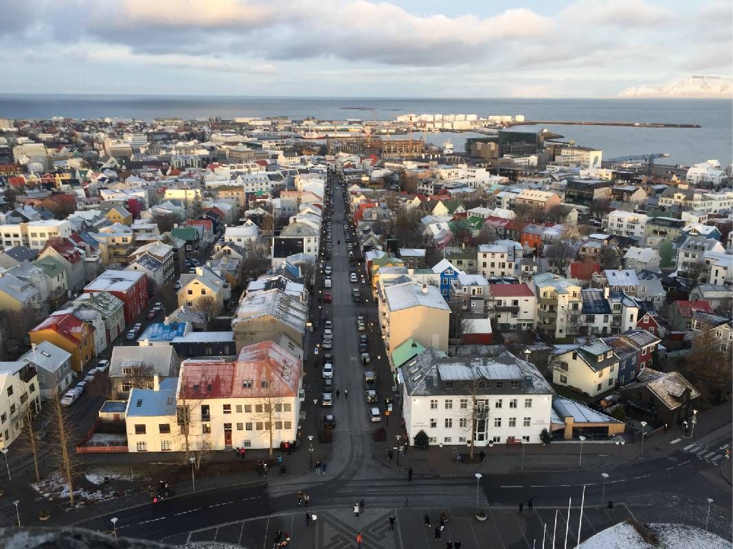 An aerial view of homes and buildings in a city. Next Avenue, travel to Iceland