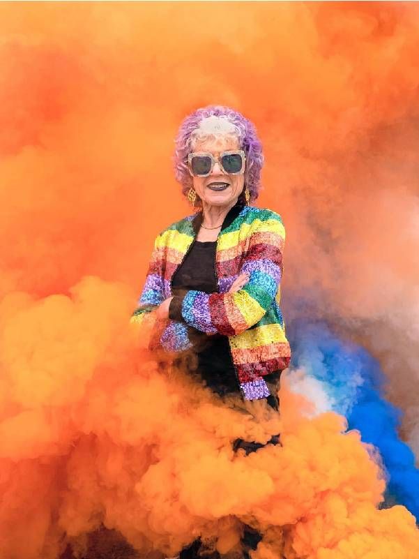 Artist Judy Chicago surrounded by colorful smoke. Next Avenue