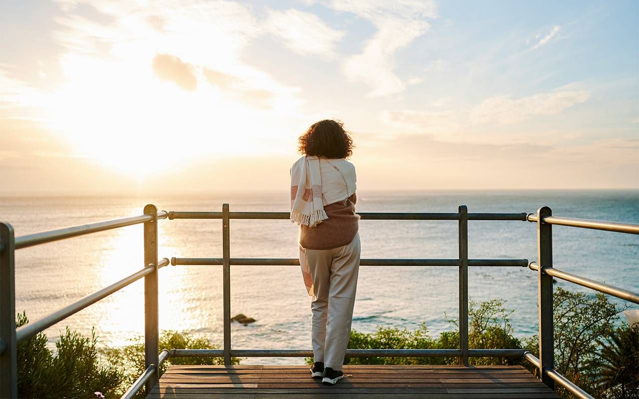A woman who is going through menopause looking out at the ocean. Next Avenue, menopause