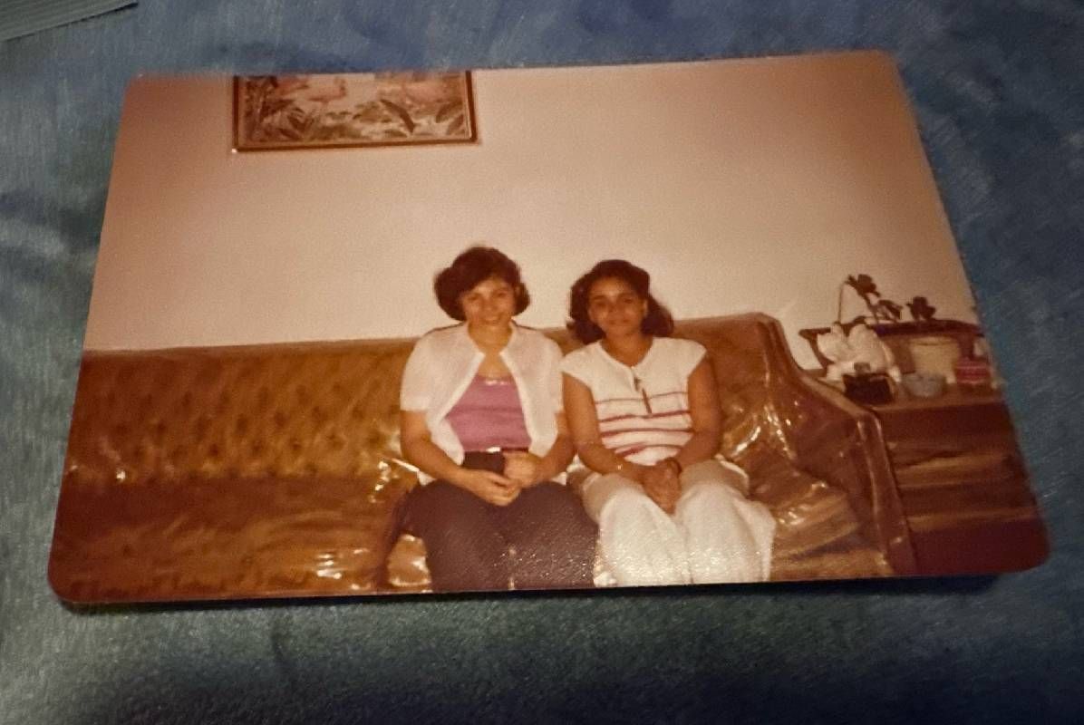 A vintage photo of two women sitting on a couch. Next Avenue