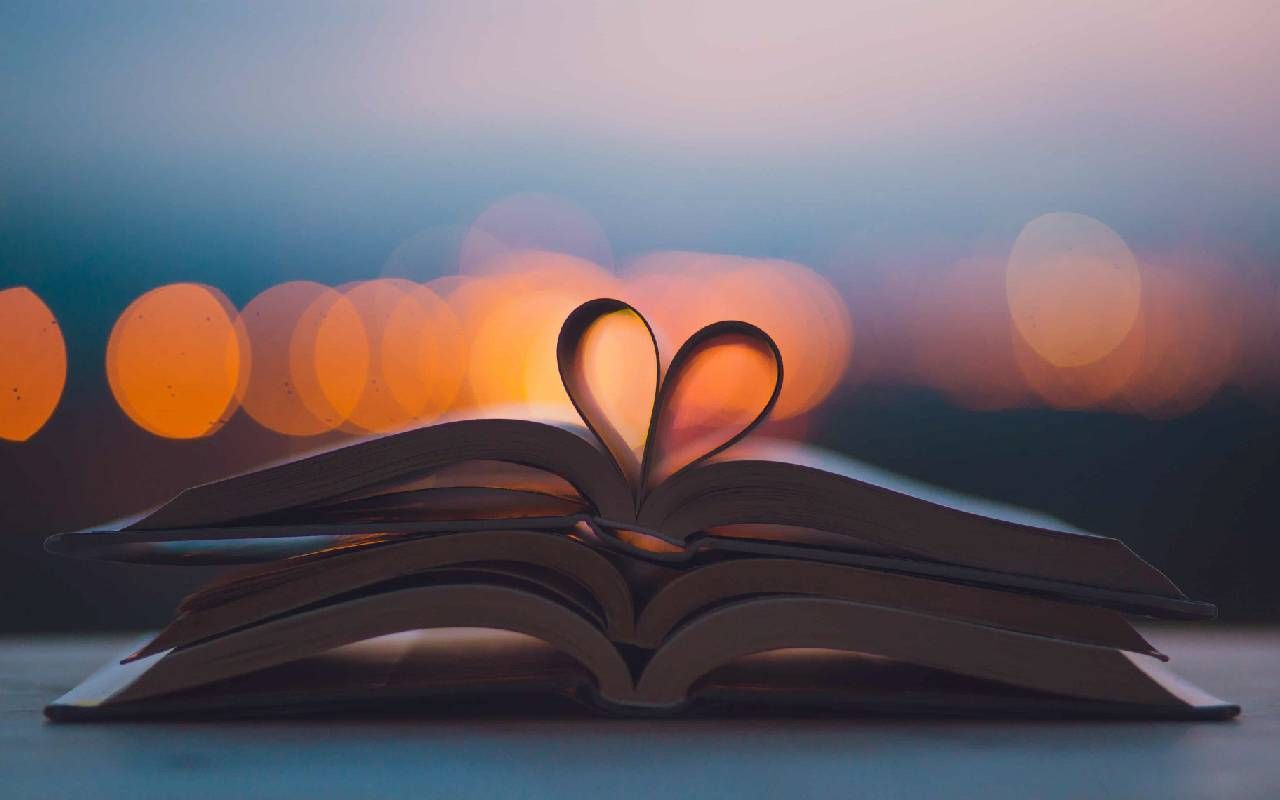Romance novels stacked on top of each other with the pages making the shape of a heart. Next Avenue