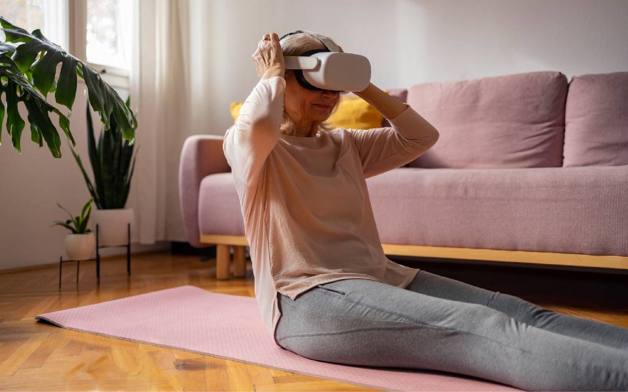 A woman putting on a VR headset before a workout. Next Avenue