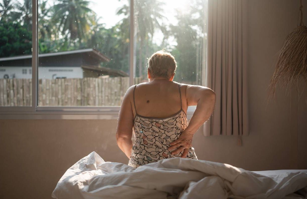A woman waking up with tailbone pain. Next Avenue, Coccydynia