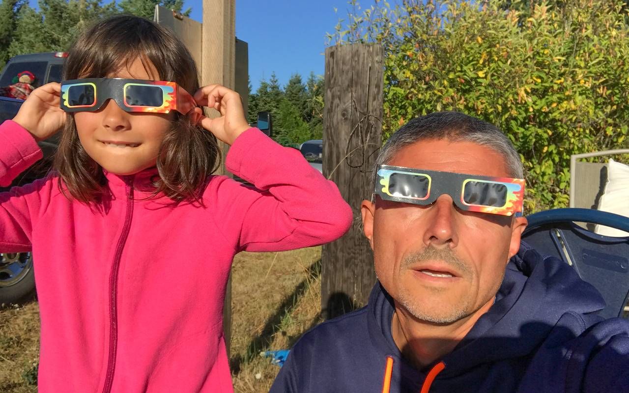 An older adult and a child wearing glasses watching the solar eclipse. Next Avenue, 2024