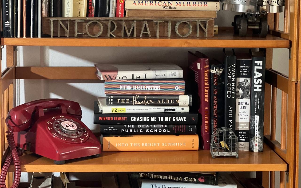 A bookshelf with a rotary phone on it. Next Avenue