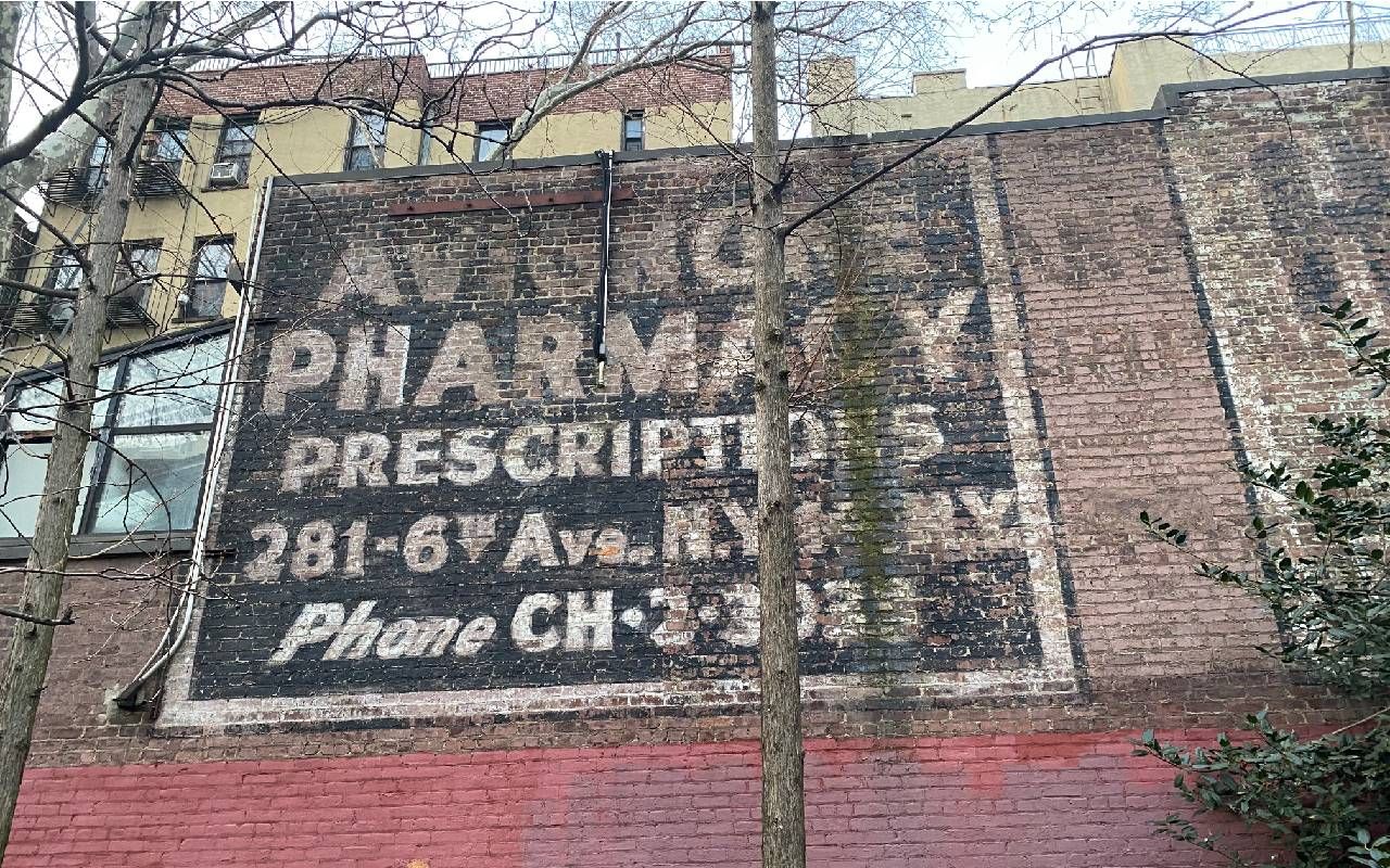 An old painted sign with a phone number. Next Avenue