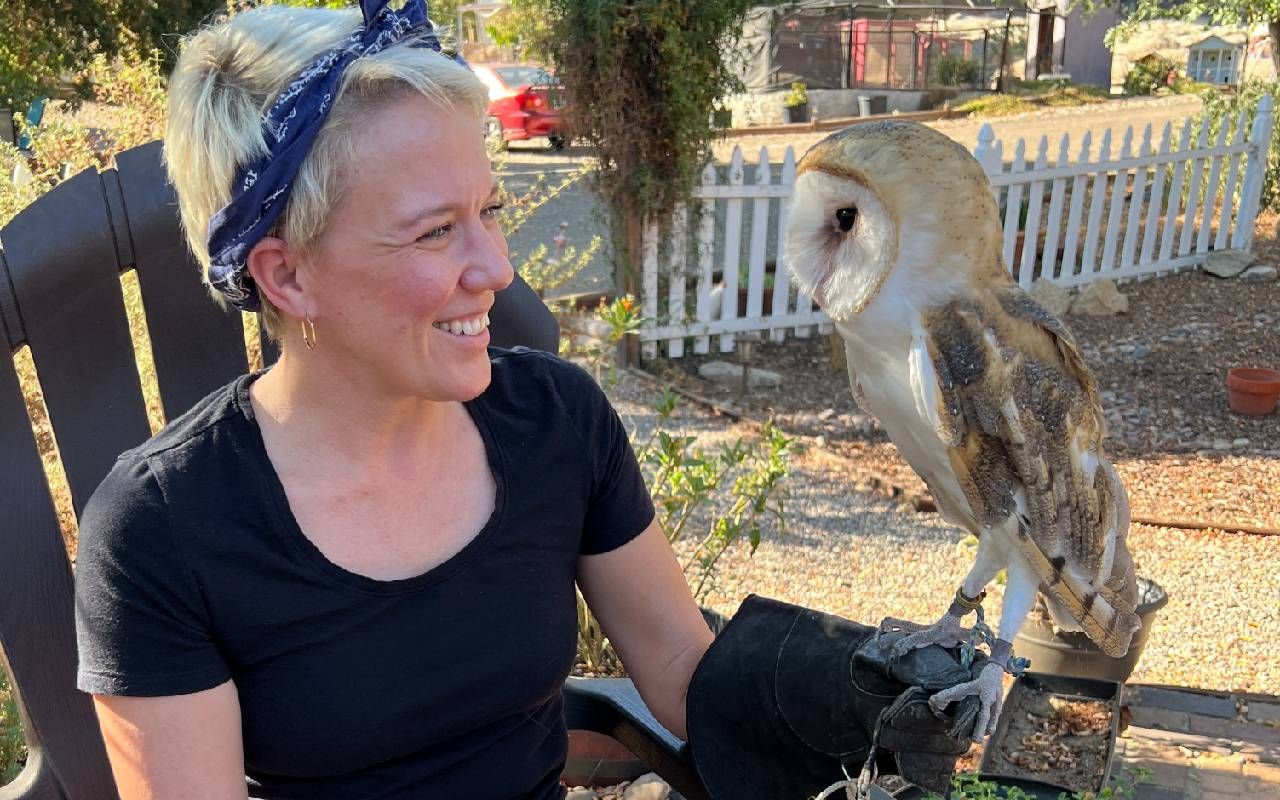 The author smiling at an owl that she is holding. Next Avenue, Courtney Ellis, Looking Up